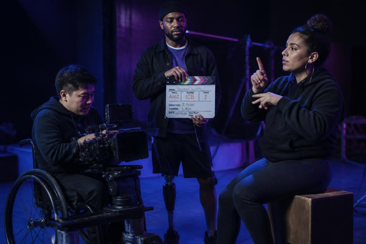 Young disabled makers directing and filming in a purple studio